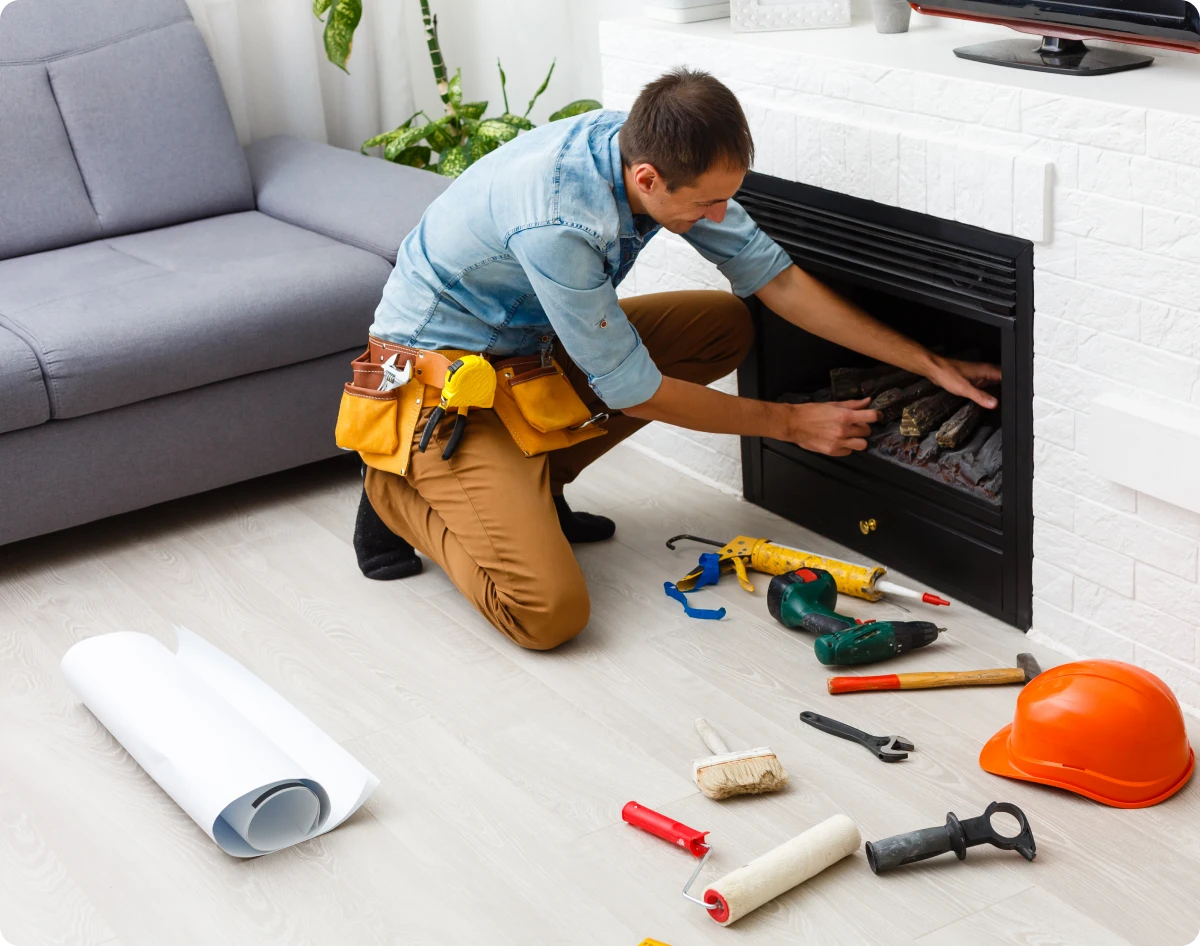Technician adjusting fireplace setup at home
